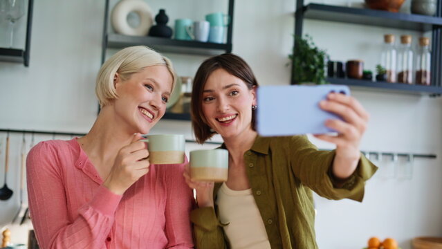 Lgbt couple snapping selfie mobile phone closeup. Happy partners preparing food - Powered by Adobe