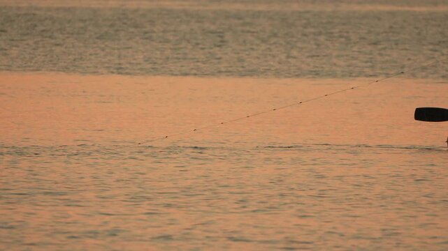 Fishing longline water tranquil golden hour fishing line extends across serene calm water.