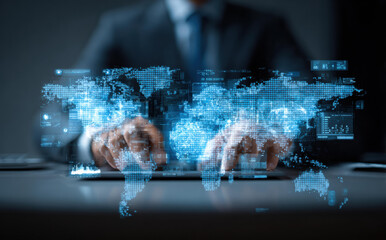 Serious businessman analyzing futuristic global business with holographic world map. Digital technology, network connection, and data visualization for focused global strategy