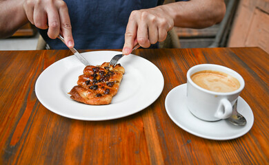 A man enjoying coffee and a pastry at a local café in Seville, Spain. The candid moment captures the relaxed atmosphere of Andalusian street cafés