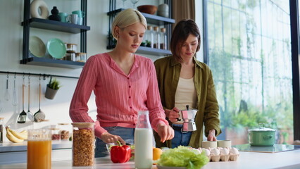 Lgbt couple cooking together in kitchen closeup. Girlfriends making breakfast