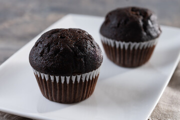 Homemade chocolate muffins on wooden table
