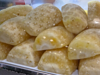 Close-up view of several frozen pineapple pieces stacked together, showing frosty surfaces and pale yellow color with visible texture from the fruit’s core and outer rind.