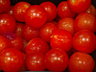 A close-up, top-down view of a dense pile of bright red, whole cherry or grape tomatoes.