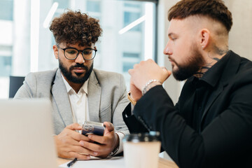 Business colleagues discussing strategy using mobile phone