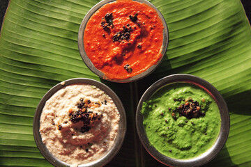 indian food chutneys on banana leaf
