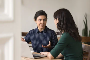 Fotobehang Muziek Confident young woman business professional mentoring female colleague at workplace  © fizkes