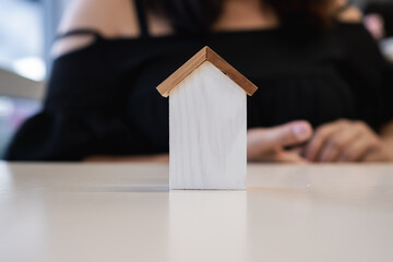 Mini wooden house model representing real estate investment, property mortgage, home loan approval, housing market planning, and financial security for future living.