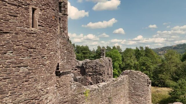 Detailed close rising drone footage of the majestic ruins of Grosmont Castle with views over the Welsh Border on sunny summer day