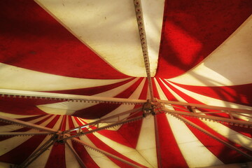 Chapiteau de toile bicolore rouge et blanc vu de dessous.