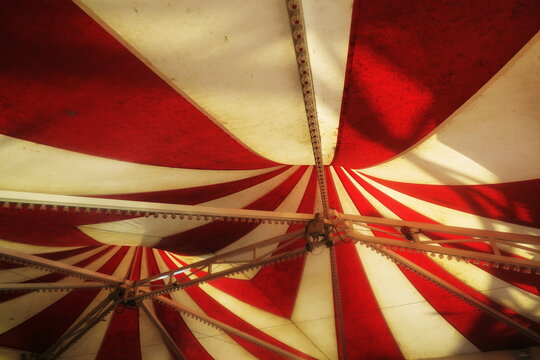 Chapiteau de toile bicolore rouge et blanc vu de dessous.