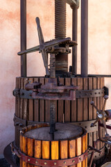 Vintage olive oil press with wooden staves and iron screws, a rustic mechanical structure once used to extract oil from olives