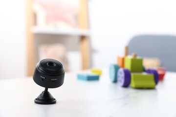 Hidden spy camera on white table in child's room. Space for text