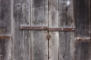 Texture of wooden door with padlock as background, closeup