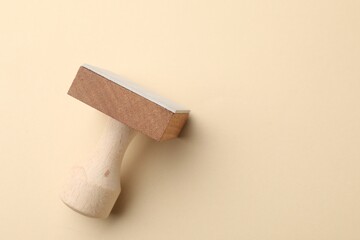 One wooden stamp on beige background, top view. Space for text