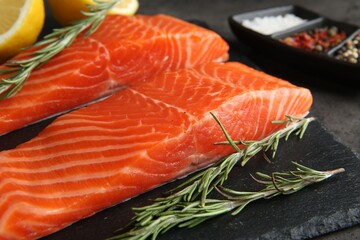 Pieces of salmon fillet and spices on grey table, closeup