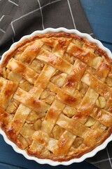 Delicious homemade apple pie in baking dish on blue wooden table, top view