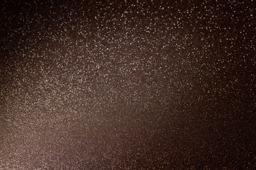 Shiny brown and gold glitter surface highlighted diagonally from left bottom, offering radiant sparkling backdrop with rich texture for creative celebration themes