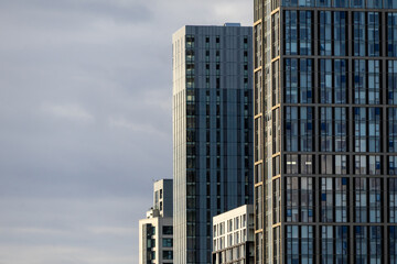 Naklejka premium Cluster of Modern Glass and Steel High-Rise Buildings Against a Cloudy Sky