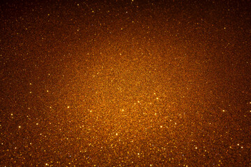 Shimmering gold textured surface illuminated in middle zone, sparkling grains form radiant highlight blending smoothly into darker edges