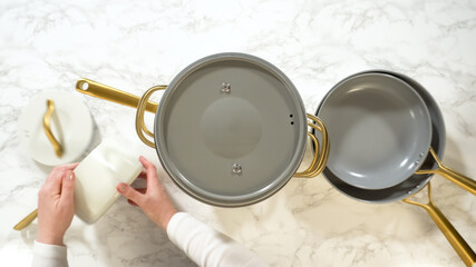 Hands arranging white ceramic cookware