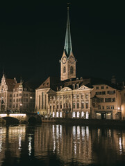 Naklejka premium Fraumunster church reflecting on limmat river at night