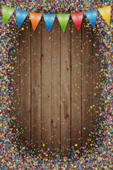 Scattered confetti and bright garlands creating a fun and lively birthday atmosphere on a wooden surface.