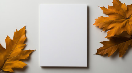 Blank white paper on a neutral backdrop, framed by two vibrant, golden fall leaves. A minimalist composition ideal for seasonal announcements and artistic endeavors.