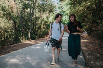Obraz premium Two friends stroll along a wooded path, carrying baskets and bags as they chat and enjoy a sunny day outdoors. Casual summer attire and natural scenery create a carefree lifestyle scene.