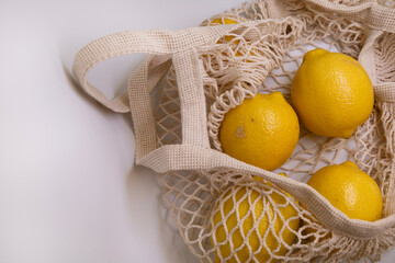 Premium Food Styling with Fresh Yellow Lemons in Mesh Bag – Flat Lay on White Background