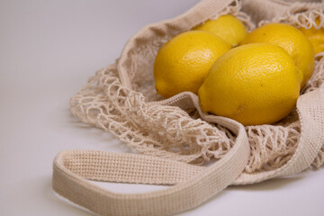 Premium Food Styling with Fresh Yellow Lemons in Mesh Bag – Flat Lay on White Background