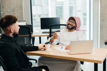 Arabian and western businessmen collaborating in office workspace
