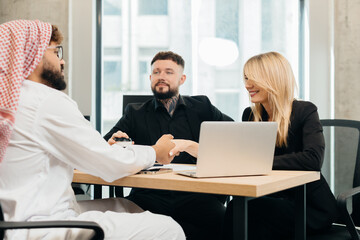 Obraz premium Arab businessman shaking hands with woman in office