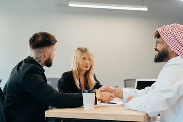 Obraz premium Diverse business partners shaking hands finalizing agreement