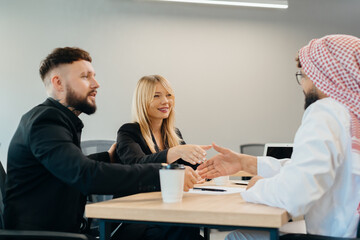 Diverse business professionals completing agreement with handshake