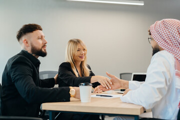Businesswoman shaking hands with arab businessman