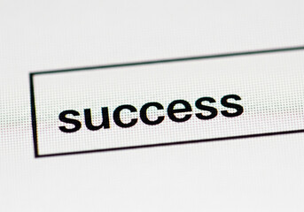 Closeup of the word success on a computer screen isolated on white background