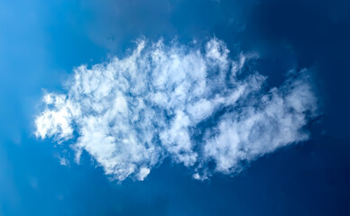 Naklejka premium A composite cloud of several wisps of rolling vapor. Wind flow forms a rain clouds that accumulates to the required critical mass. Beautiful seascape natural composition simple blue sky with steam.