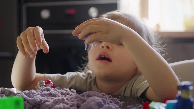 Female child engages with soft purple modeling compound