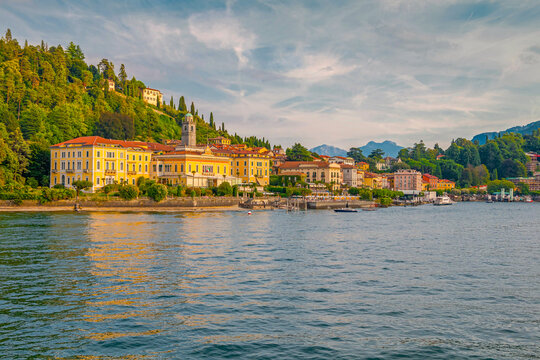 Sunset view of Bellagio from a ferry on Lake Como, with golden light reflecting on the water, charming lakeside buildings, and surrounding mountains creating a magical evening scene