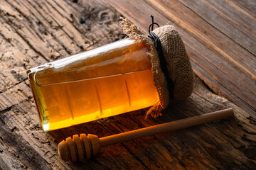 Honey jar and honey dipper on wooden background