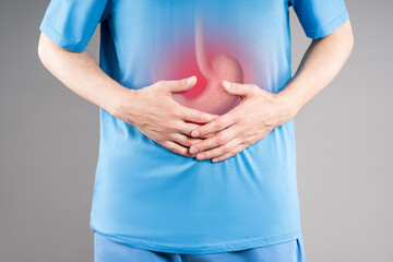 Stomach ulcer, man with abdominal pain, symptoms of gastritis, diseases of the digestive system, gray background