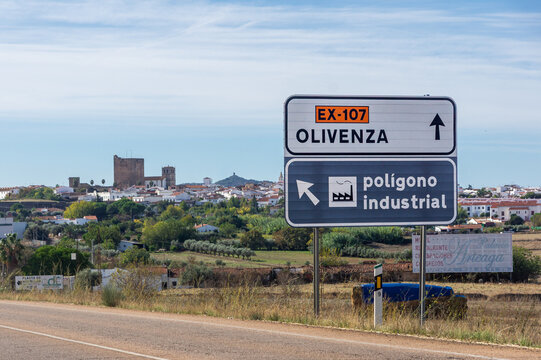 Badajoz, Spain. October 2, 2025. Entrance sign to the town of Olivenza along the road from Badajoz, with the town in the background, highlighting the keep (or homage tower) of its medieval castle.