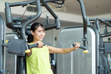 Naklejka premium ジムで筋トレをする若い女性 撮影協力：スポーツクラブ&サウナスパ ルネサンス 幕張24