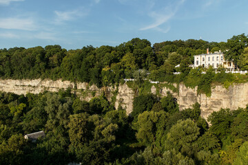 Tranquil outdoor scene of lush vegetation and cliffs in Kamianets-Podilskyi, Ukraine, inviting relaxation, adventure, and scenic discovery.