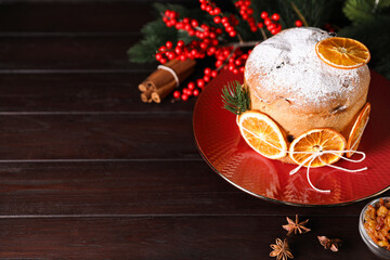 Christmas food. Delicious Panettone cake, ingredients and festive decor on wooden table, closeup. Space for text