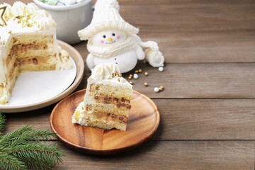 Piece of delicious cake with Christmas decor on wooden table, closeup. Space for text