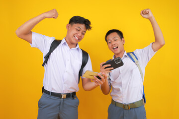 Excited Students Celebrate Game Victory on Smartphones in Vibrant Classroom