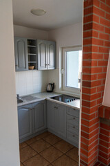 Small modern kitchen with grey cabinets and natural light