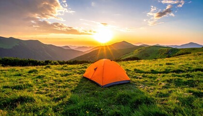 Orange camping tent pitched on a grassy meadow with rolling hills and mountains under a vibrant sunrise sky with sun rays shining through clouds